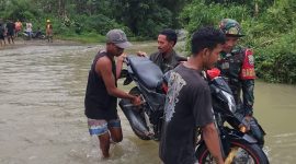 Babinsa Serda Candra Kirana Sam bersama dengan warga bantu angkat motor saat kali Wae Galang Banjir di Desa Golo Ketak kecamatan Boleng pada, Kamis 15/01/2026