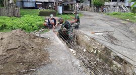 Babinsa Koramil 1630-01 Komodo ya g bertugas di Kecamatan Boleng, bantu warga memperbaiki Deker yang rusak menuju ke Pasar Terang